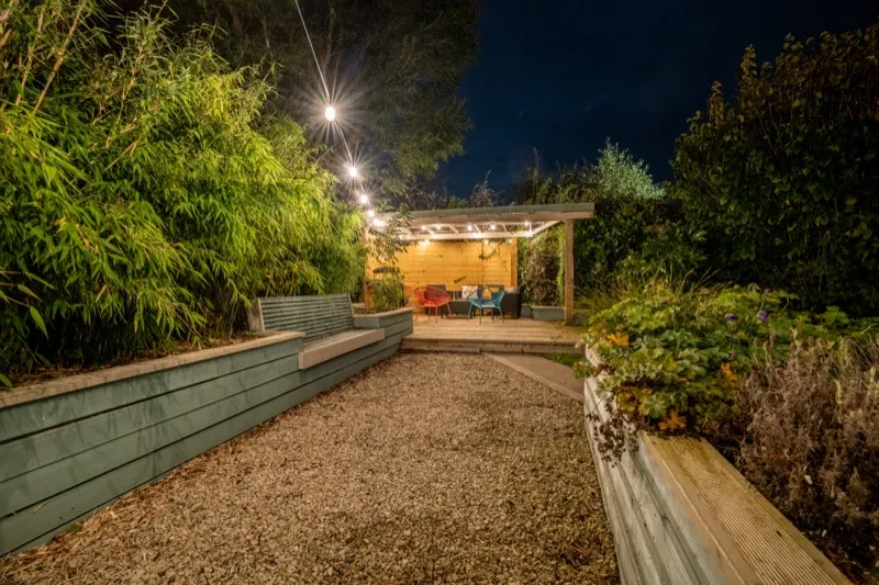 Garden terrace lit by festoon lights at night