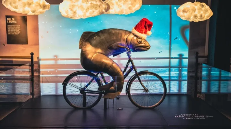 Whimsical fish-on-a-bicycle sculpture with a Santa hat at the Guinness Storehouse