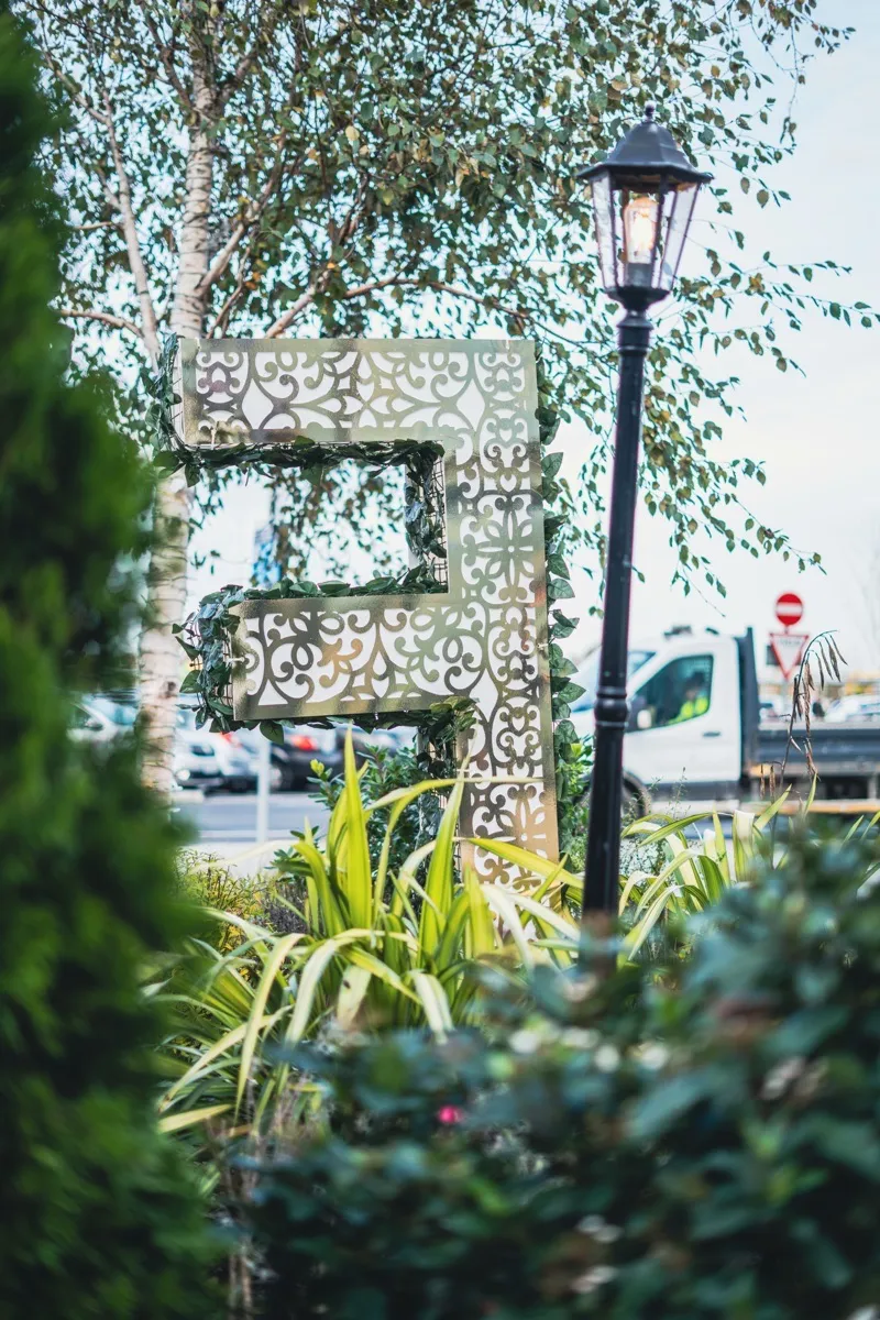 Decorative metalwork sculpture surrounded by greenery at Liffey Valley