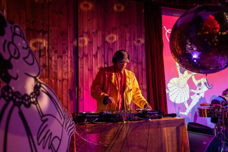 DJ performing under pink lighting at the Sugar Club