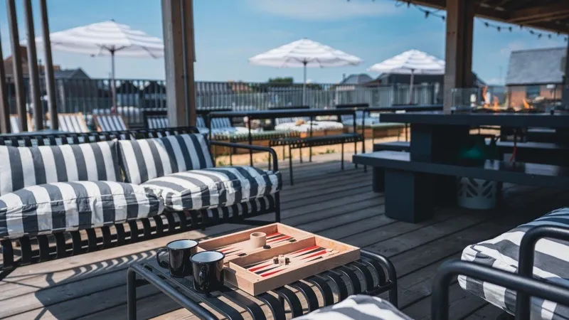 Outdoor terrace with striped seating and backgammon at a coastal venue