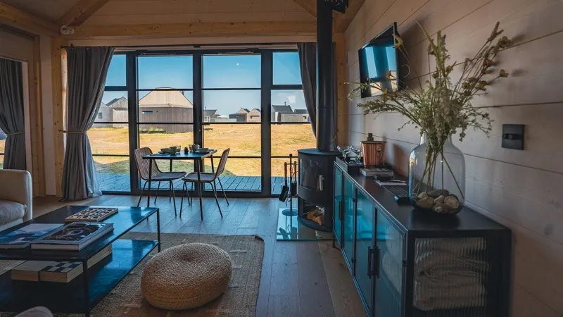 Cabin interior with dining table, wood stove and natural light