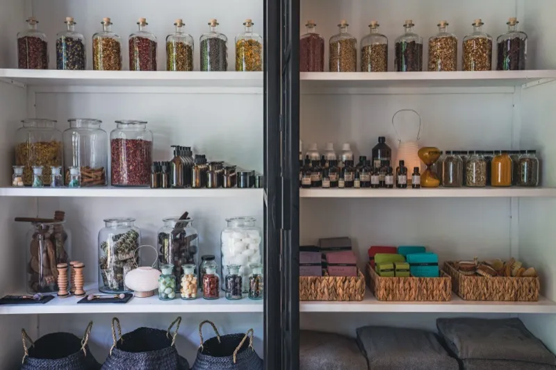 Apothecary-style shelving with glass jars and artisan products